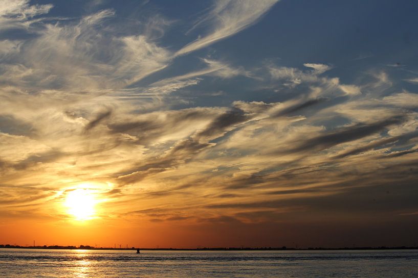 mooie zonsondergang aan zee met wolken in de lucht na een warme zomerdag van Angelique Nijssen