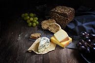 repas rustique avec différents fromages, pain complet et raisins sur une table en bois sombre, espac par Maren Winter Aperçu