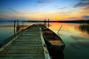 Bootssteg mit Ruderboot im Sonnenuntergang