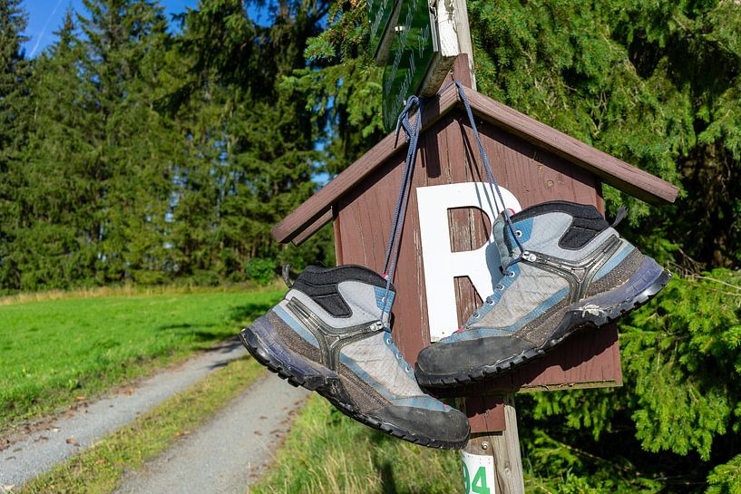 Une paire de chaussures de randonnée sur un panneau du Rennsteig dans la forêt de Thuringe par Animaflora PicsStock