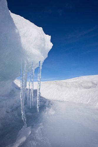 Symmetrische ijspegels met ijsrichel en blauwe lucht op het Baikalmeer