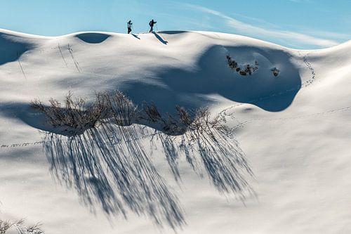 Winterwandelaars op een maagdelijk witte heuvelrug in Oostenrijk