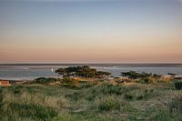 Zicht vanaf Terschelling naar zeiljacht in zonsondergang