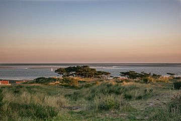 Zicht vanaf Terschelling naar zeiljacht in zonsondergang van Jolanda Kleij