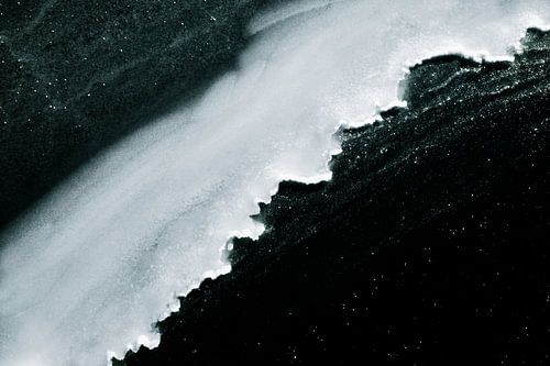 IJsrand boven donker water – winterabstract gefotografeerd vanaf een brug