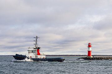 Tugboat and pier tower on the Baltic coast in Warnemünde by Rico Ködder