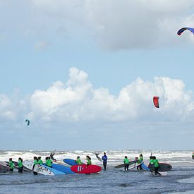 Kleurige surfplanken, kitesurfers en surfkleding bij les in de branding bij Zandvoort aan Zee sur Suzan Baars