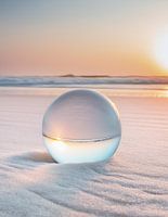 Magische reflectie: glazen bol in de zonsondergang op het strand