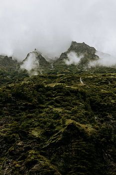 Mighty rock face with moss and clouds