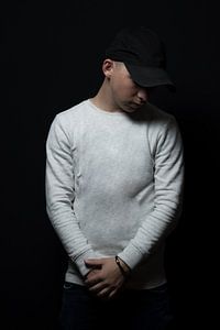 Un adolescent avec une casquette noire regarde en bas