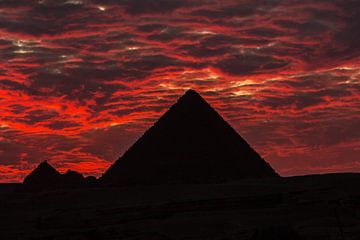 De dramatische zonsondergang achter een van de 3 grote Pyramides in Cairo - Egypte van Michiel Ton