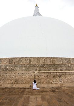Biddende vrouw bij een stoepa