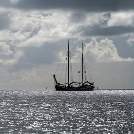 Zeilboot tegen de schittering van de zon in de Waddenzee nabij het eiland Terschelling van Tonko Oosterink