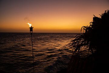 Fakkel bij zonsondergang op Curaçao van Laura V