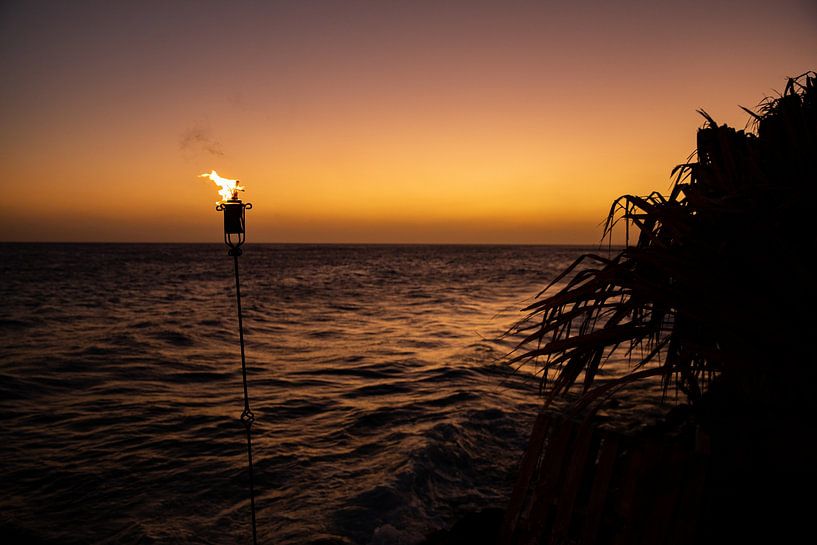 Fakkel bij zonsondergang op Curaçao van Laura V