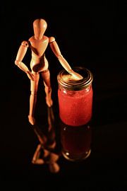 Canned fruit with wooden doll and black background by Hans-Jürgen Janda