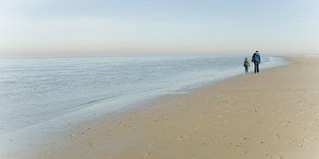 Un père et son fils se promènent sur la plage de Texel. sur Margo Schoote