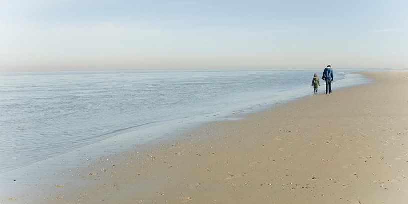 Father and son walk along the beach on Texel by Margo Schoote