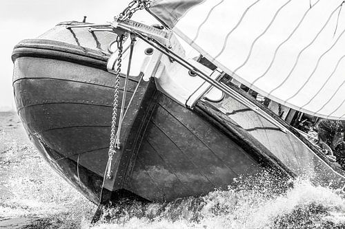 Zwart-wit close-up van een skûtsje in de golven