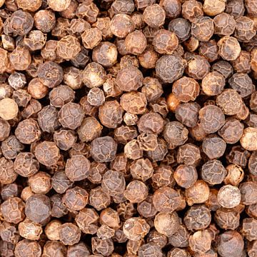 Les grains de poivre noir s'éparpillent, créant une texture d'épice alimentaire sur de-nue-pic