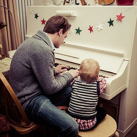 Vater und Sohn spielen Klavier von Kim Groenendal