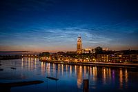 Lichtende nachtwolken boven de skyline van Deventer