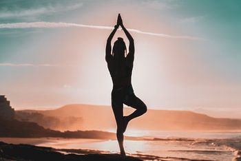 Femme faisant du yoga sur la plage
