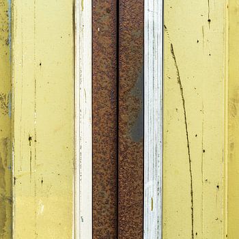 Abstraktes Linienwerk mit Holz und rostigem Rohr in Gelb und Braun
