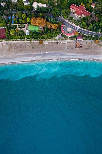 Colorful houses and road. Hotels among the green park on the seafront with turquoise water and the b
