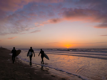 Surfeurs au coucher du soleil