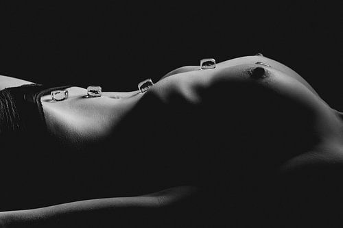 Topless vrouw bedekt met ijsblokjes – sensuele kunstfoto