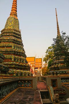 Blick vom ersten Bürgersteig auf das reich verzierte Dach, das von Teilen der Chedis im Wat Pho flan von kall3bu