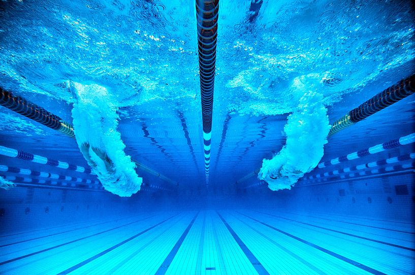 twee zwemmers springen in een blauw zwembad van Alexander Baumann