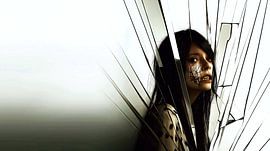 Vrouw met littekens achter een gebroken spiegel