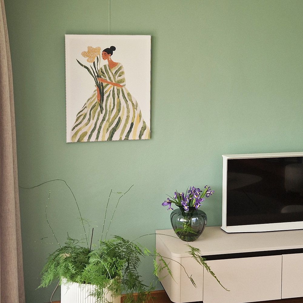 Elegant woman in green dress with large flower  by But First Framing 