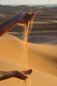 Jouer avec les mains avec le sable du Sahara. 