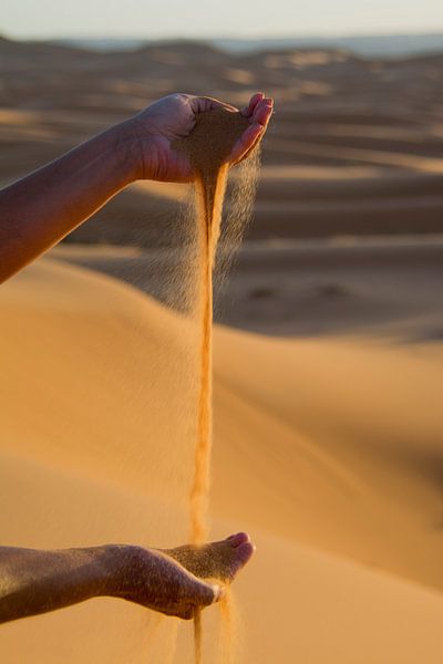 Jouer avec les mains avec le sable du Sahara.  sur Ton de Koning