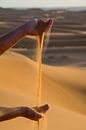 Jouer avec les mains avec le sable du Sahara.  sur Ton de Koning Aperçu