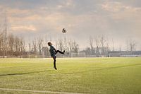 Kind probt mit dem Ball auf dem Fußballfeld