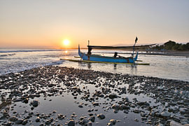 A jukung fishing boat on the coast at sunset in Medewi, Bali by Fotos by Jan Wehnert
