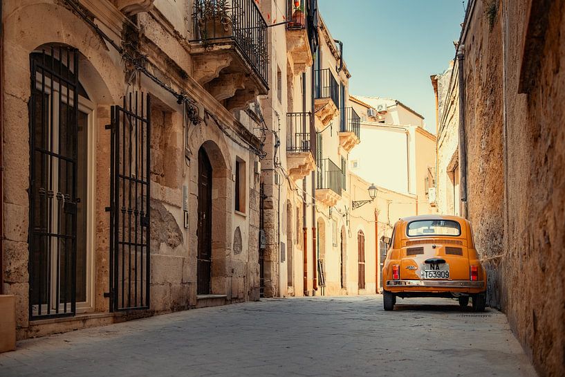 Een gele oldtimer Fiat 500 in Syracuse, Sicilië, Italië. van Ron van der Stappen