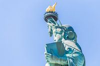 Vue rapprochée de la Statue de la Liberté sur un ciel bleu