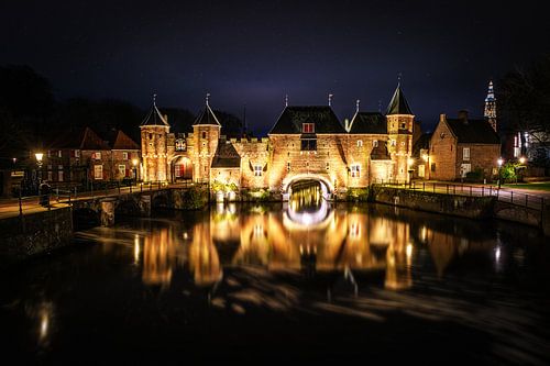 De koppelpoort van Amersfoort in de avond met reflectie en sterren