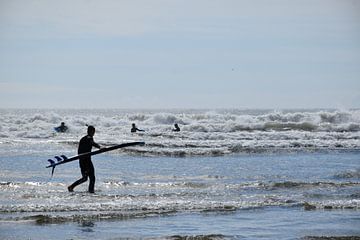 Een surfer op het strand van Claude Laprise