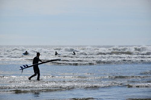 Een surfer op het strand