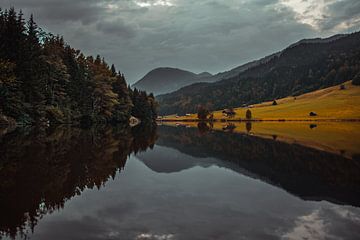 Autumnal mountain lake idyll. Reflection in the Alpine foothills