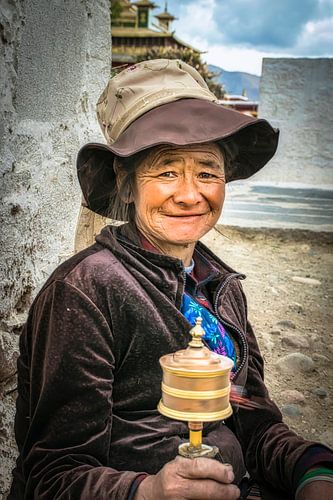 Tibetaanse vrouw met draaiende gebedsmolen, portret