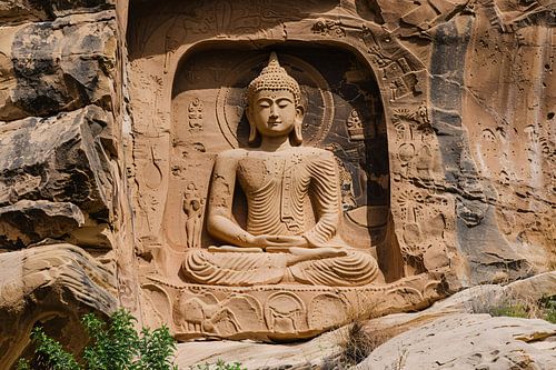Sculpture de Bouddha méditatif dans un mur de pierre