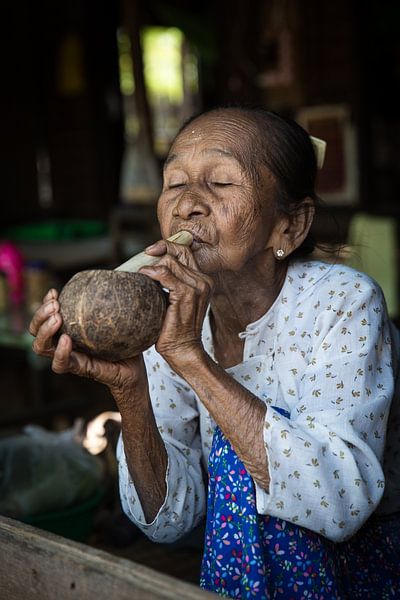 Alte Frau raucht traditionelle Stumpen Zigarre vor ihrem Haus in Baghan in Myanmar von Wout Kok