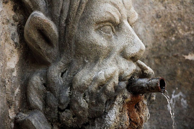 Gargouille sculptée dans la pierre avec un tuyau en cuivre dans la bouche où l'eau sort. par martin von rotz